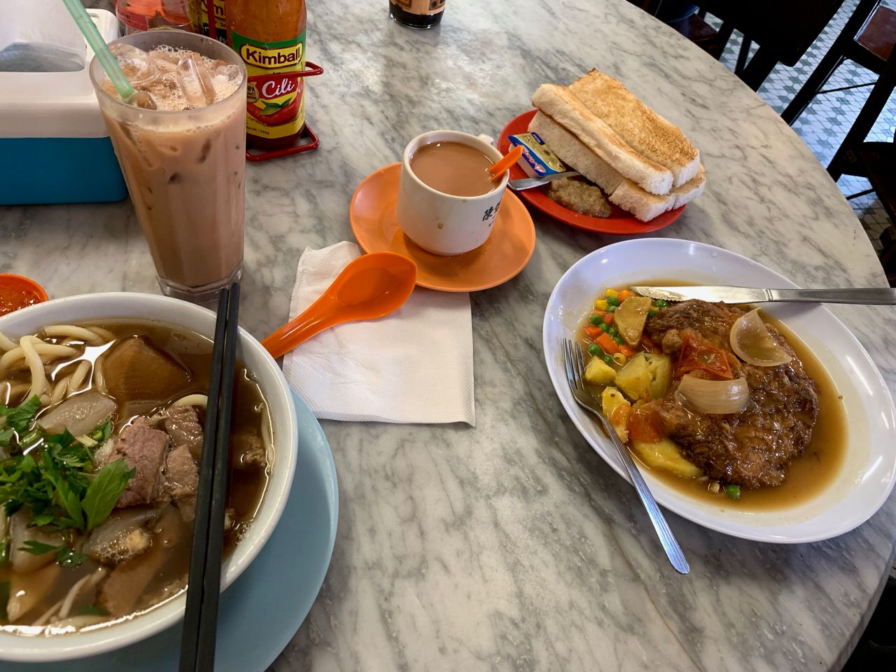 Breakfast with beef noodle soup, milk tea and toast with coconut paste